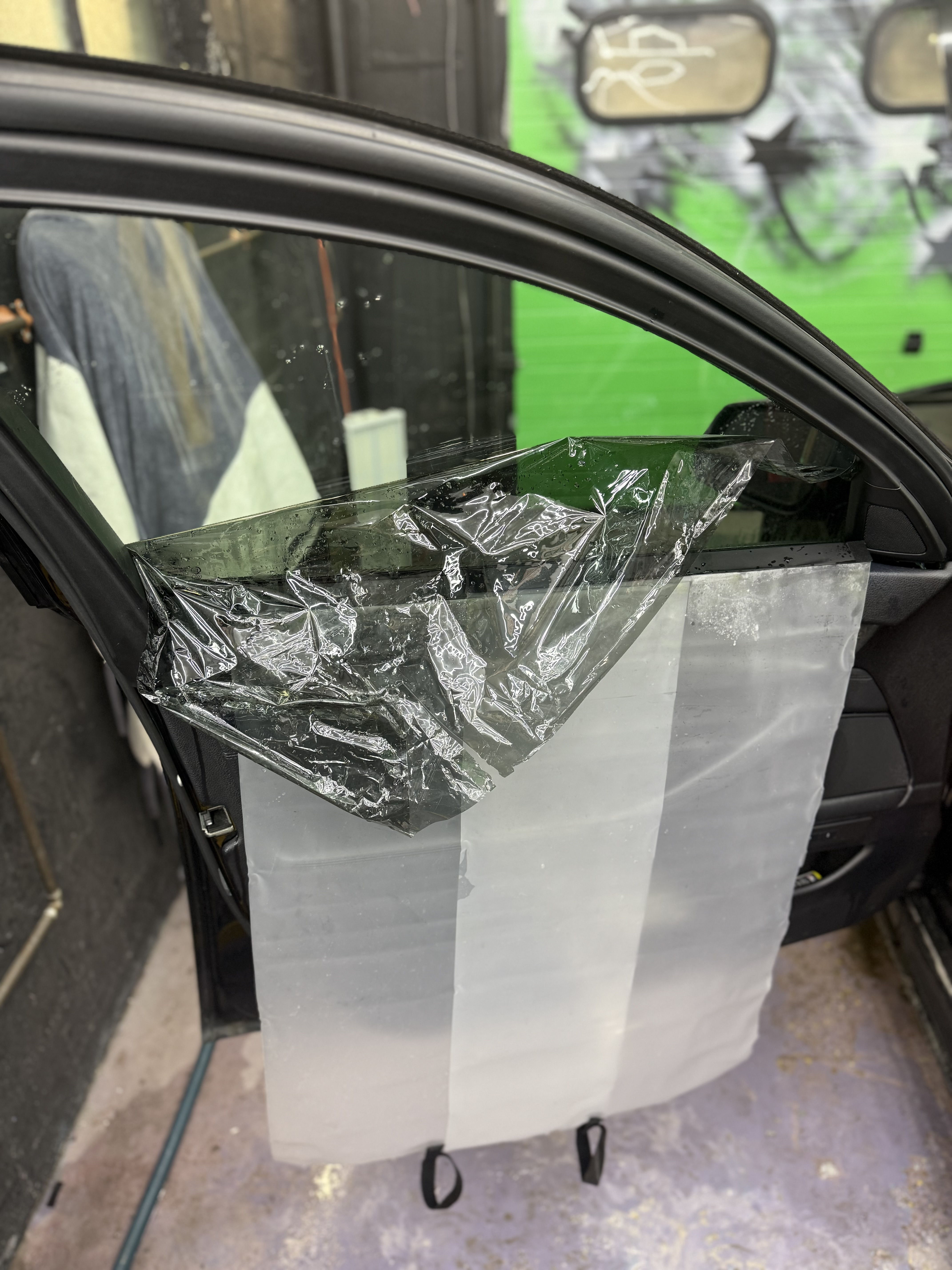 Car door panel with protective plastic during detailing process